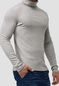 Graues Langarm-Turtleneck-Shirt aus einem glatten, dehnbaren Stoff. Verfügt über ein enges Design mit hohem Kragen und gerippten Bündchen.