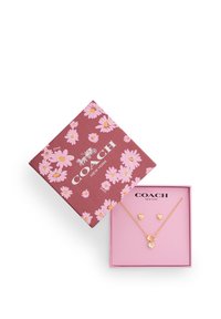 Coach jewelry set with gold heart-shaped necklace and matching earrings in pink floral gift box.