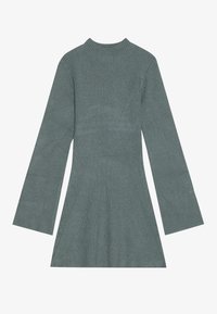 Vestito a maglia a coste di un verde tenue, con maniche lunghe a sbuffo e scollatura alta. Le cuciture evidenti valorizzano la forma.