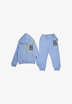 Felpa con cappuccio in pile azzurro chiaro per bambini con cerniera e pantaloni abbinati, entrambi con toppe colorate con la scritta "RICH" sul petto e sulla coscia.