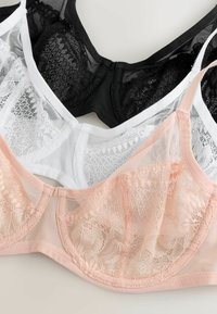 Sæt med tre blonder underwired bh'er i sort, hvid og lyserød, arrangeret overlappende på en flad overflade.