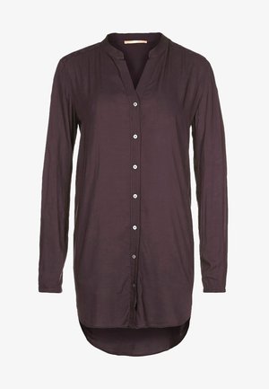 Chemisier à manches longues de couleur violet foncé pour femme, avec col mandarin et ourlet arrondi asymétrique.