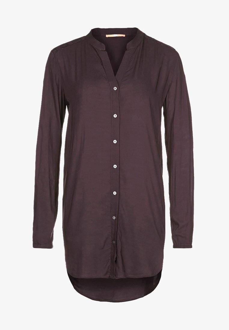 Chemisier à manches longues de couleur violet foncé pour femme, avec col mandarin et ourlet arrondi asymétrique.