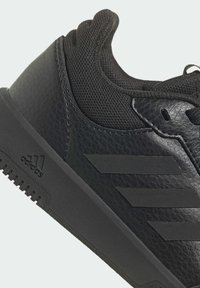 La chaussure de sport noire présente une tige en synthétique texturé, des accents en mesh et un détail de logo. Conçue avec un col rembourré et une semelle en caoutchouc.
