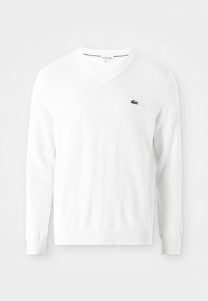 Sweater branco em corte em V, feito de um tecido suave, com mangas longas e um pequeno logo de crocodilo verde no lado esquerdo do peito.