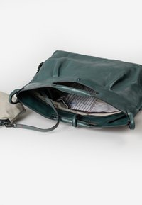 Borsa in pelle teal con apertura superiore, dotata di una fodera interna a righe e una pochette beige rimovibile con tracolla. Texture liscia e design minimalista.