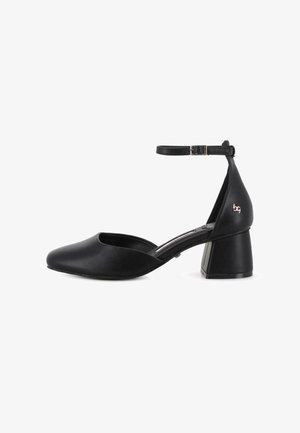 Zapato de mujer de cuero negro con tirante al tobillo, tacón cuadrado y punta cerrada, que presenta un pequeño logo metálico en el contrafuerte del tacón.