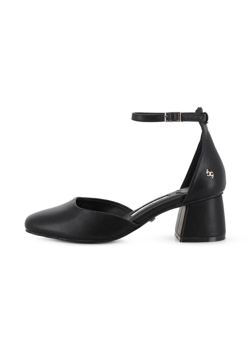 Zapato de mujer de cuero negro con tirante al tobillo, tacón cuadrado y punta cerrada, que presenta un pequeño logo metálico en el contrafuerte del tacón.