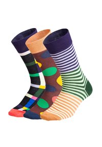 Tres pares de calcetines de tripulación: uno con una cuadrícula negra y colores, otro marrón con grandes lunares y otro verde a rayas, todos con patrones variados y tapas texturizadas.