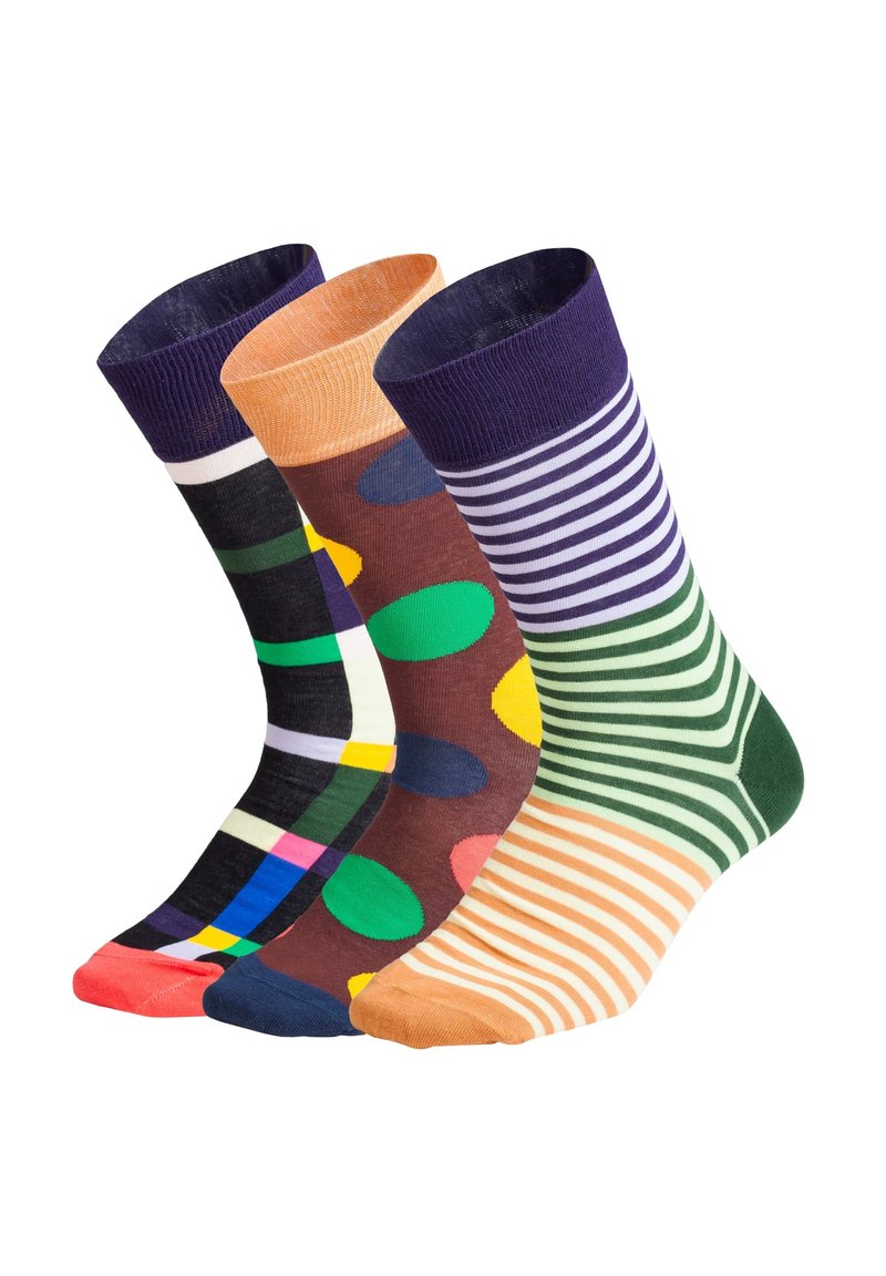 Trois paires de chaussettes de travail : à carreaux noirs avec des couleurs, brunes avec de grands points et vertes rayées, présentant des motifs variés et des bords texturés.
