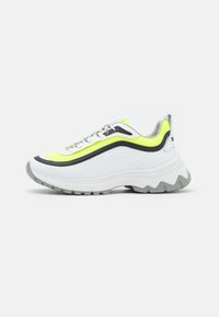 Sneaker chunky bianchi con accenti in rete gialla e nera, suola in gomma grigia texturizzata, lacci riflettenti e silhouette distintiva a forma di onda.