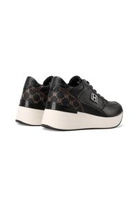 Zapatillas de plataforma negras con suelas blancas, acentos de patrón marrón y un logo plateado en secciones de cuero y tejido texturizado.
