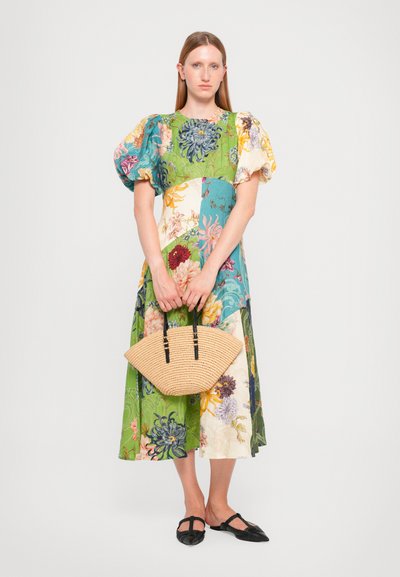 Abito midi floreale in patchwork nei toni del verde, blu e giallo. Presenta maniche a sbuffo, corpetto arricciato ed è abbinato a una borsa in tessuto intrecciato.