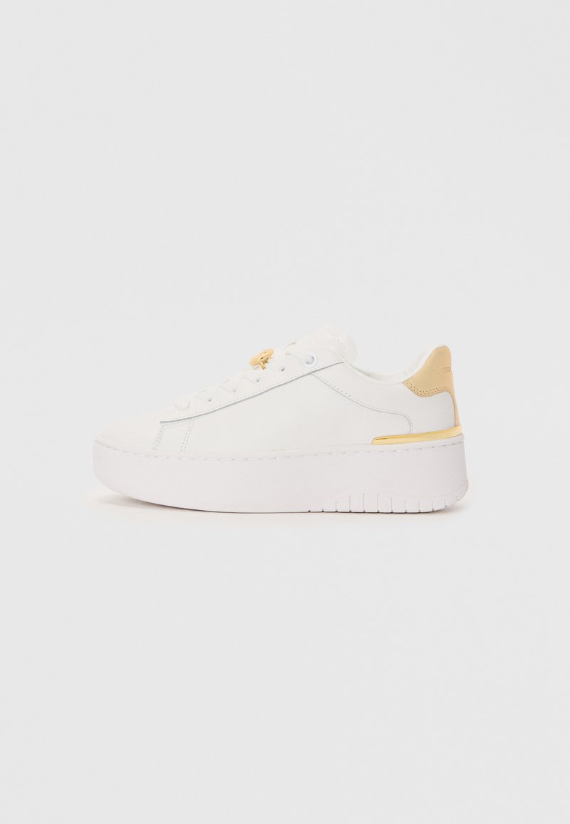 White sneaker with a smooth leather upper, contrasting yellow heel tab, thick white platform sole, and minimalistic lace-up design.