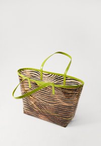 Borsa tote trasparente con motivo a strisce di zebra in sfumature di marrone e nero, con manici e rifiniture di un vivace verde.
