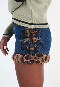 Denim mini skirt featuring a leopard-print faux fur trim and floral embroidered design with dark accents.