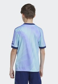 Maillot bleu clair avec un motif en vagues, à manches courtes et un col marine. Présente le logo "SPORT HONDA" sur la manche gauche.