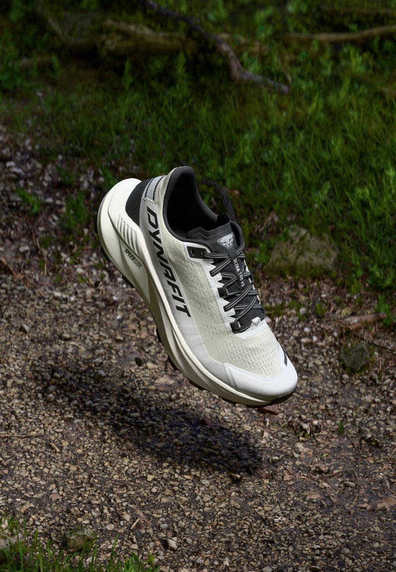 Lekkie buty sportowe w beżowo-czarnym kolorze, z teksturowaną cholewką, amortyzowaną podeszwą i sznurowadłami, z logo po boku.