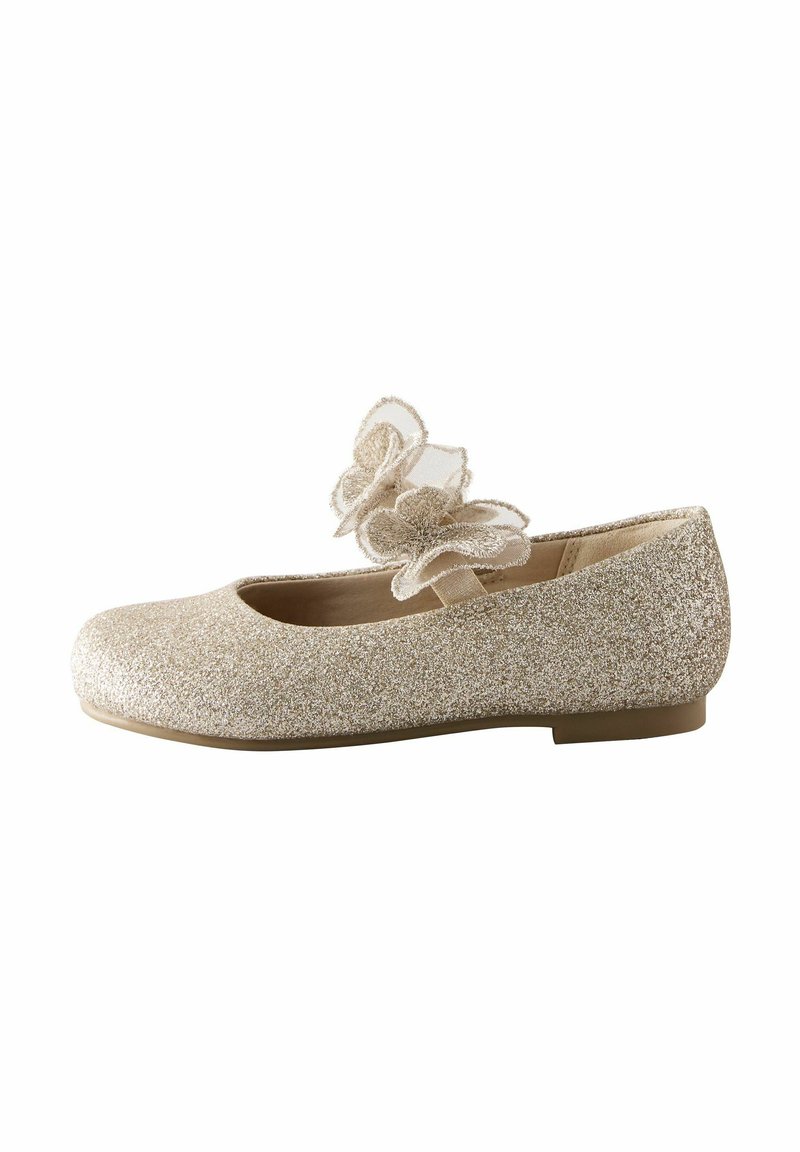 Glittrande guld balletlägenhet med rund tå och låg klack, prydd med två dekorativa tygblommor på framremmen.