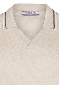 Polo de punto beige claro con un patrón texturizado, con cuello en V y un collar con rayas marrones y blancas. Etiqueta visible en el interior.