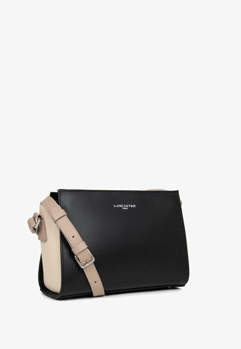 Zwarte en beige leren schoudertas met een rechthoekig ontwerp, verstelbare schouderband en een reliëflogo aan de voorkant. Glad van structuur.