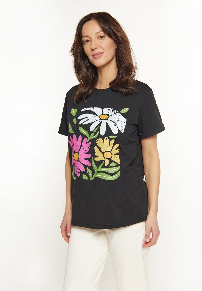 Sort bomulds T-shirt med et blomstermotiv i hvid, pink og gul med grønne blade. Kortærmet, afslappet pasform.