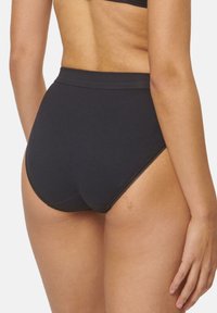 Högmidjade svarta trosor i mjukt tyg, med en slät yta, subtil spetskant längs benöppningarna och minimala sömmar.