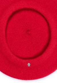 Red wool beret with a small silver decorative emblem centered near the brim, photographed on a white background.