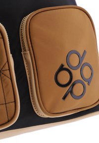 Bolso de nylon negro y marrón con dos bolsillos con cremallera marrones, un patrón acolchado y un logo negro impreso sobre la superficie marrón.