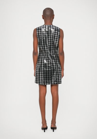 Αμάνικο μαύρο και ασημί φόρεμα με σχέδιο καρό, σε εφαρμοστή γραμμή και με λείο, γυαλιστερό υφή.