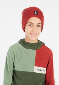 Rød strikket hue og farveblokeret fleece hoodie i grøn og rød. Hoodien har en hætte, blød tekstur og et logo på brystet.