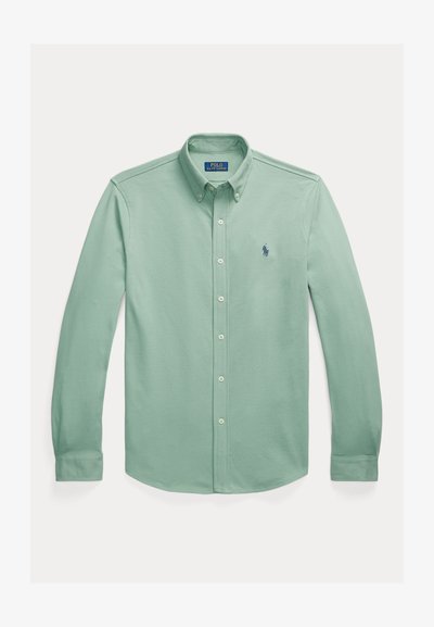 Camisa de botão verde-claro feita de algodão. Apresenta um colarinho clássico, mangas longas e um logótipo bordado no peito.