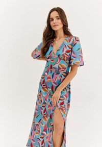 Maxi šaty z lehkého materiálu, s živým listovým vzorem v modré, růžové a oranžové barvě, s hlubokým výstřihem do V a krátkými rukávy.
