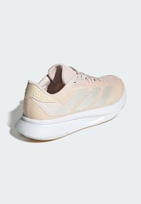 Roze sportieve schoen met ademend mesh bovenwerk, textuurontwerp, witte accenten en een gevoerde zool, met drie strepen aan de zijkant.