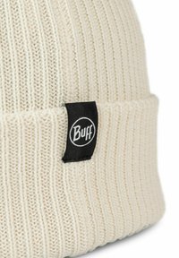 Gorro blanco de punto con textura acanalada y un puño plegado. Presenta una etiqueta circular negra con el logo de "Buff" cosido al lado.