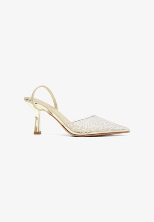 Zapato de tacón alto tipo slingback dorado con puntera puntiaguda, decorado con perlas blancas y pequeños brillantes en la superficie superior.