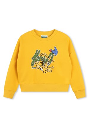 Sudadera amarilla con texto verde "Kenzo", un tigre juguetón y un gráfico de un pájaro azul en la parte frontal, puños y dobladillo acanalados.
