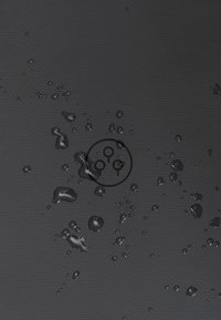 Materiale nero testurizzato con gocce d'acqua e un logo circolare al centro. La superficie presenta un motivo a nido d'ape per una migliore presa.