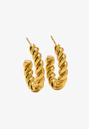 Skręcone złote kolczyki w kształcie kółek z błyszczącym, grubym plecionym wzorem i zapięciami na post. Na białym tle.