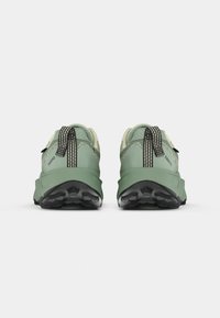 Groene wandelschoenen met een gestructureerd bovenwerk, zwarte rubberen zolen en gestreepte lusjes bij de hiel. Lichtgewicht, duurzame constructie.