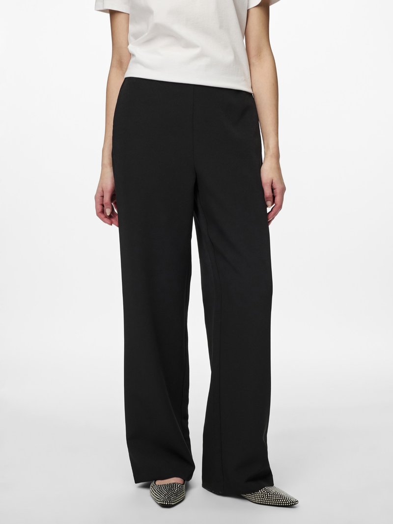 Pantalons larges noirs en tissu doux, présentant une texture lisse et une coupe ajustée. Design uni sans motifs ni accents visibles.