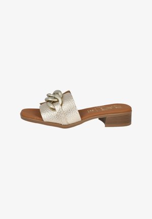 Sandalia tipo slide en cuero metálico dorado con una tira texturizada, que presenta un acento decorativo de cadena y un tacón bajo en marrón.