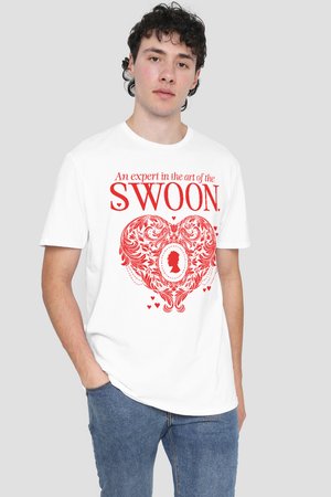 Young man wearing white t-shirt with red text "An expert in the art of the SWOON" and a large ornate heart design.