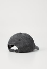 Black fabric baseball cap featuring a curved brim, six-panel design, and adjustable metal strap at the back. Textured finish.