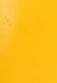 Bright yellow surface with a smooth texture, featuring scattered droplets of water, highlighting its glossy finish.