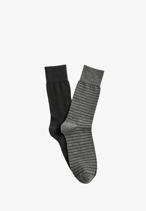 Un calzino nero e un calzino grigio con sottili strisce orizzontali nere, mostrati fianco a fianco su sfondo bianco.