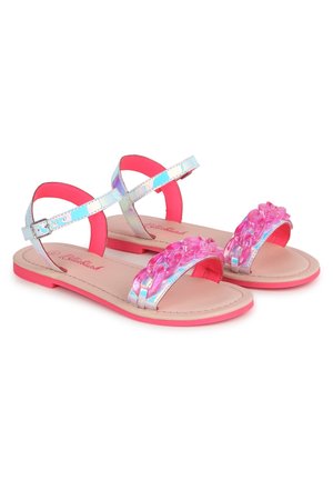 Børnesandaler med flade såler med iriserende sølvfarvede remme, pink kædeoverdekoration over tæerne og pink såler, sikret med ankelspænder.