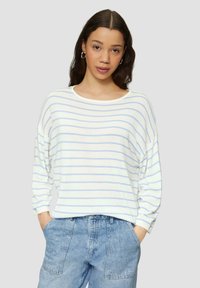 Pull rayé blanc et bleu clair avec un col rond large et une coupe décontractée, associé à un short en denim taille haute. Texture douce.