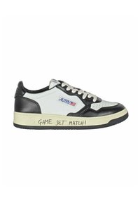 Sneaker in pelle bianca e nera con pannelli testurizzati, punta rotonda e suola in gomma. Presenta la scritta "GAME SET MATCH!" sul lato della suola.