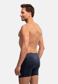 Boxer briefs blu scuro con una vestibilità aderente, vita elastica, texture liscia e design minimalista adatto per l'abbigliamento sportivo.